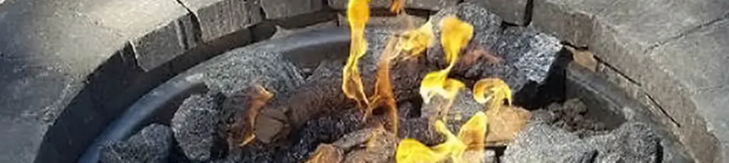 Gas flames rising through lava rock in an outdoor fire feature